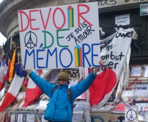 Un homme brandissant une pancarte "Devoir de mémoire"