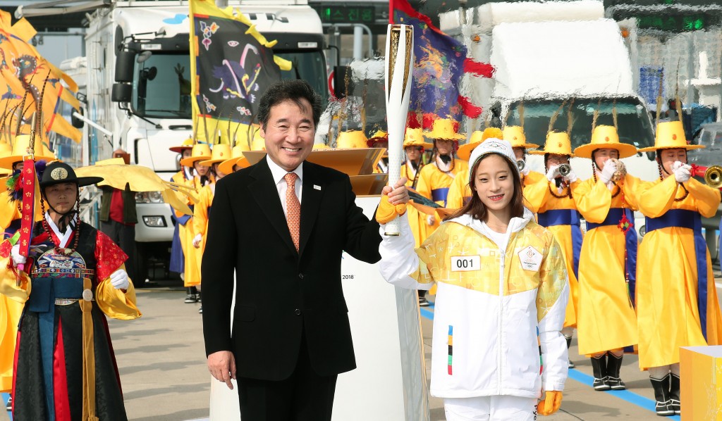 Le ministre de la Culture, du Sport et du Tourisme Do Jong-hwan tient la flamme olympique accompagné de You Young, plus jeune championne nationale de patinage artistique.Auteur : Jeon So-hyang / korea.net / Korean Culture and Information Service (licence CC)